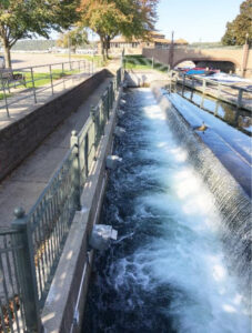 Spillway with water flowing over, showing the decorative railings and lights from the 2002 reconstruction.